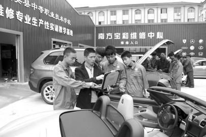 大英縣中等職業學校通過“引企入?！?，將企業維修中心建到了校園內，圖為企業專業技師向學生講解高檔轎車的保養維修技巧。